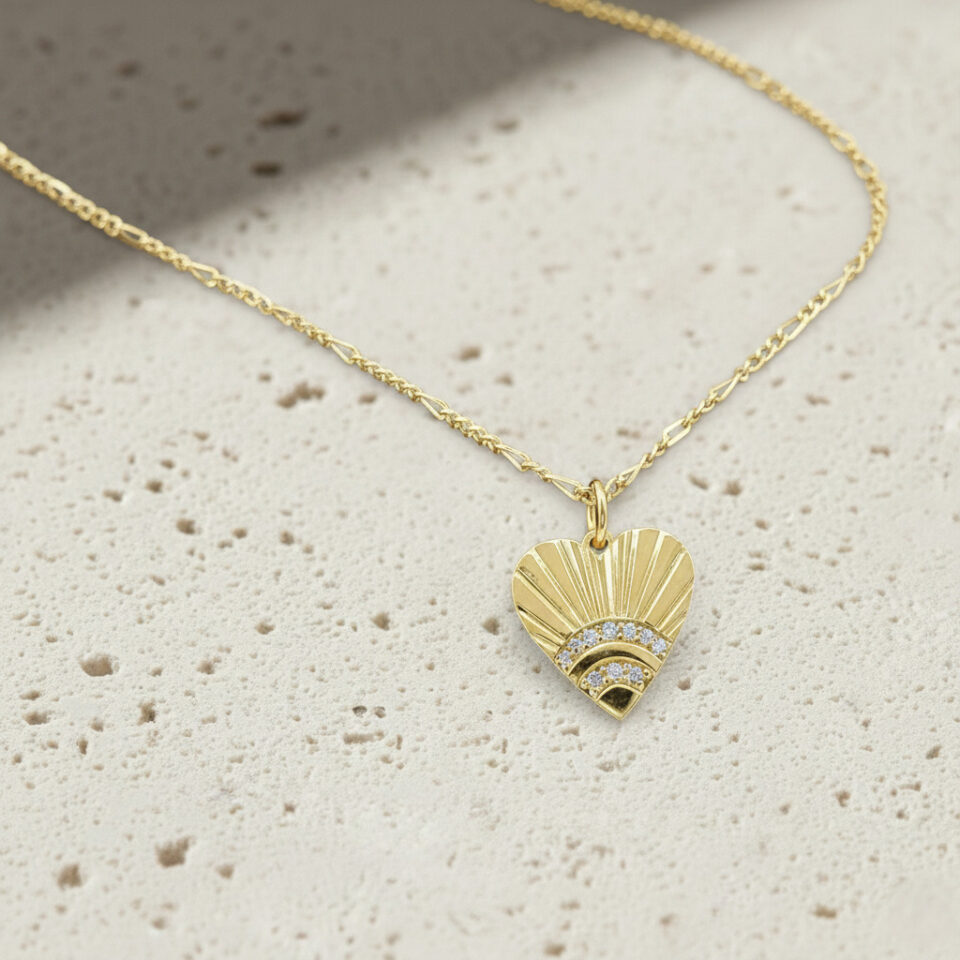 Textured sunrays heart pendant in gold finish with cubic zirconia, crafted by Jaipur jewelry manufacturer