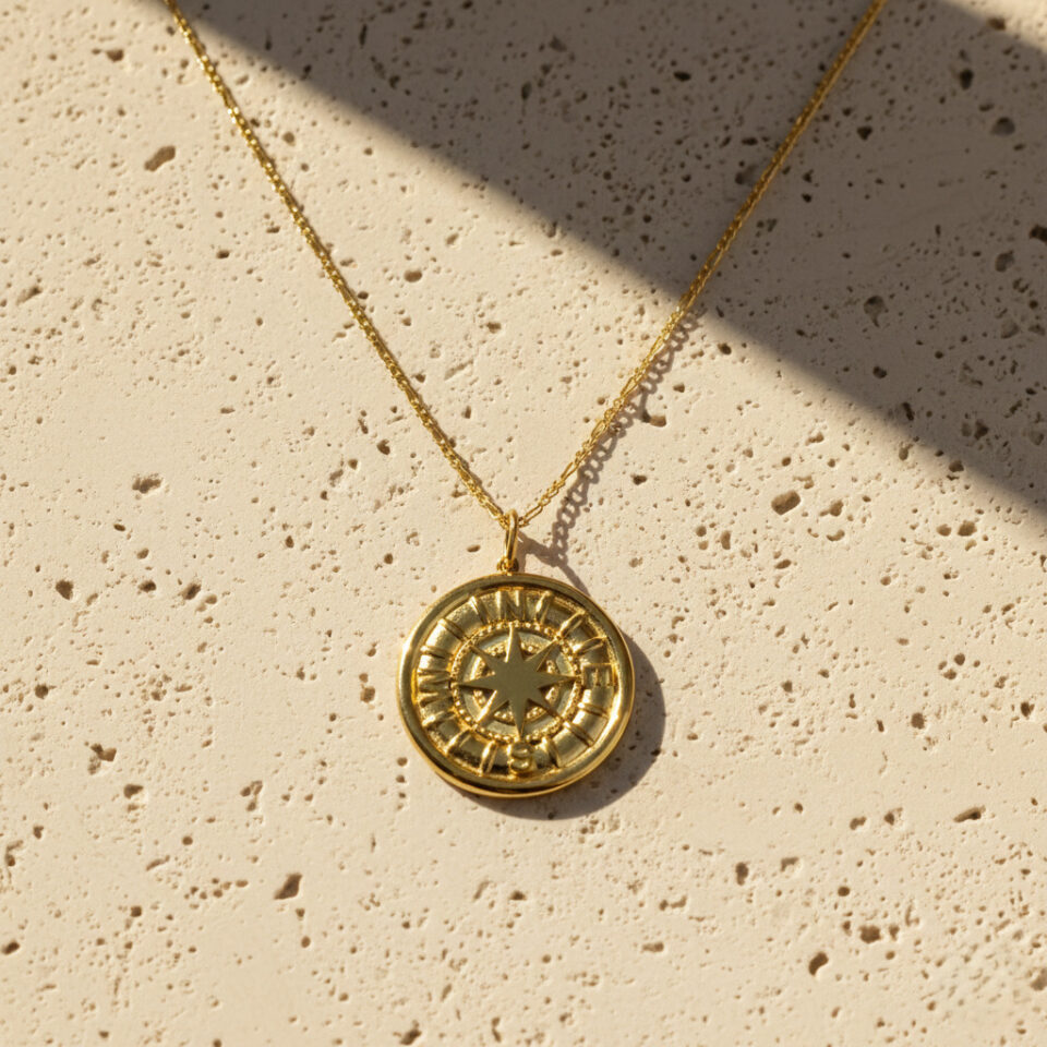 Gold round pendant with engraved compass design