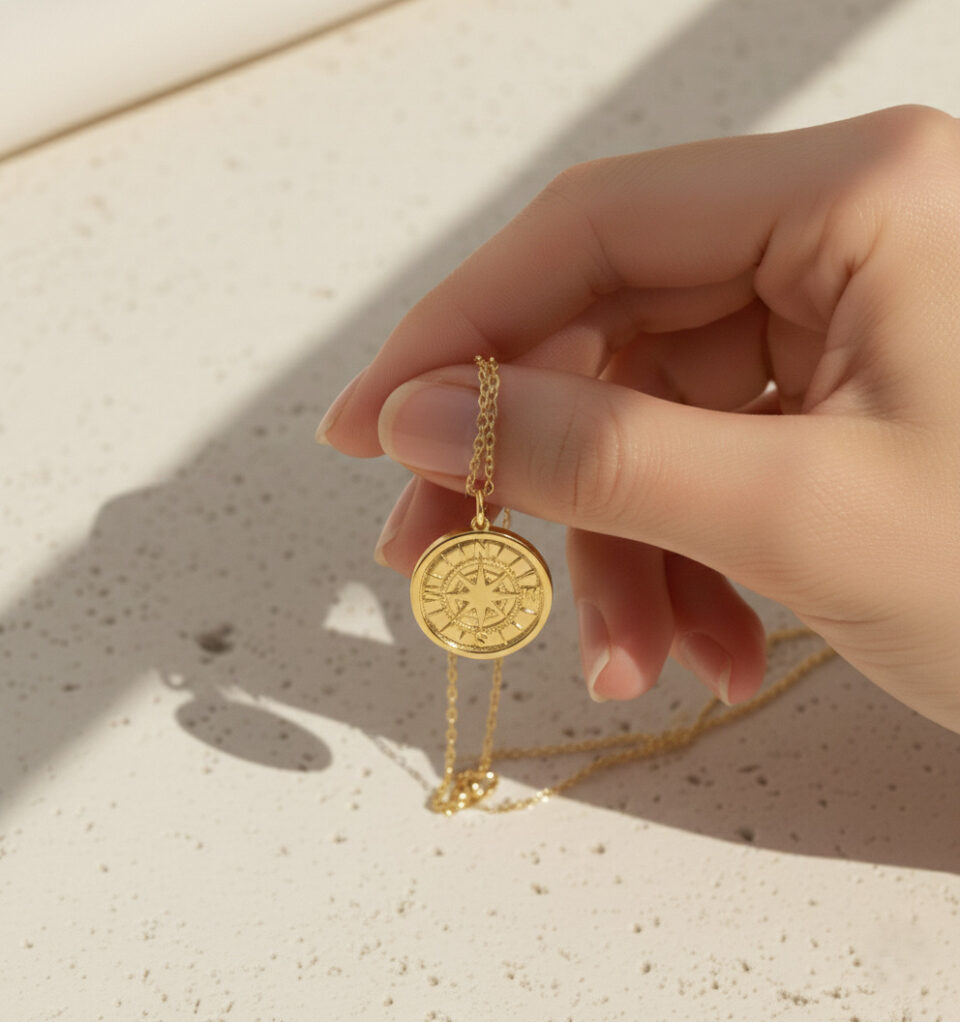 Gold compass star pendant necklace on textured background